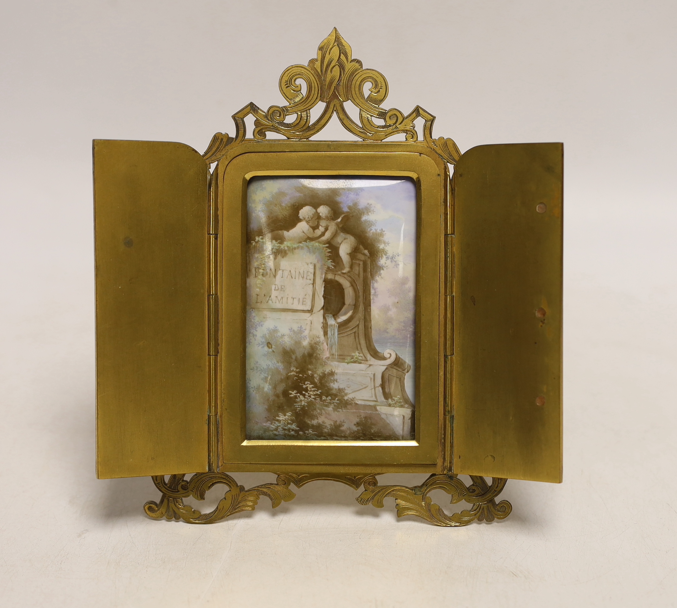 A French Palais Royale easel enamel plaque, inscribed ’’Fontaine de L'amitie’’ [fountain of friendship], retailed by Rodrigues of Piccadilly, 16.5cm high